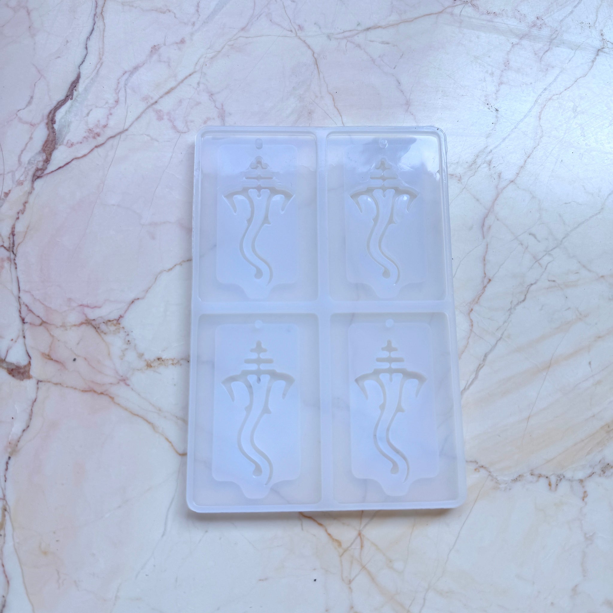 Clear silicone ice tray with engraved designs on a marble surface ganeshji resin mould