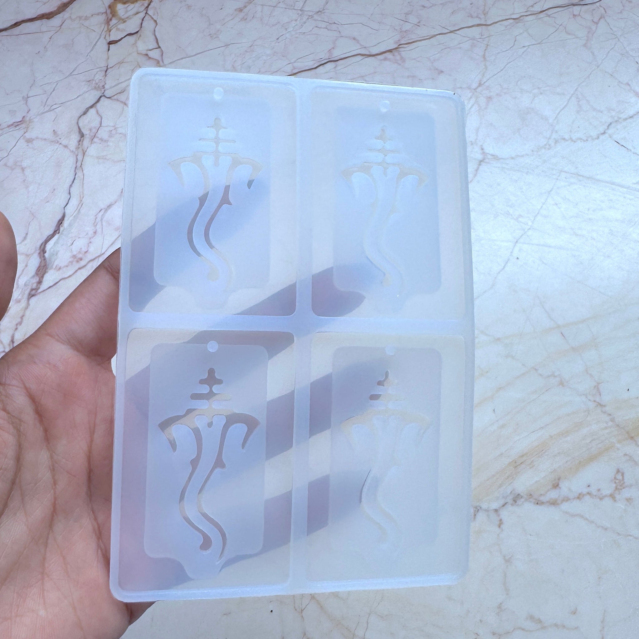 Clear silicon mould with engraved designs of ganesha which can be used in keychains 