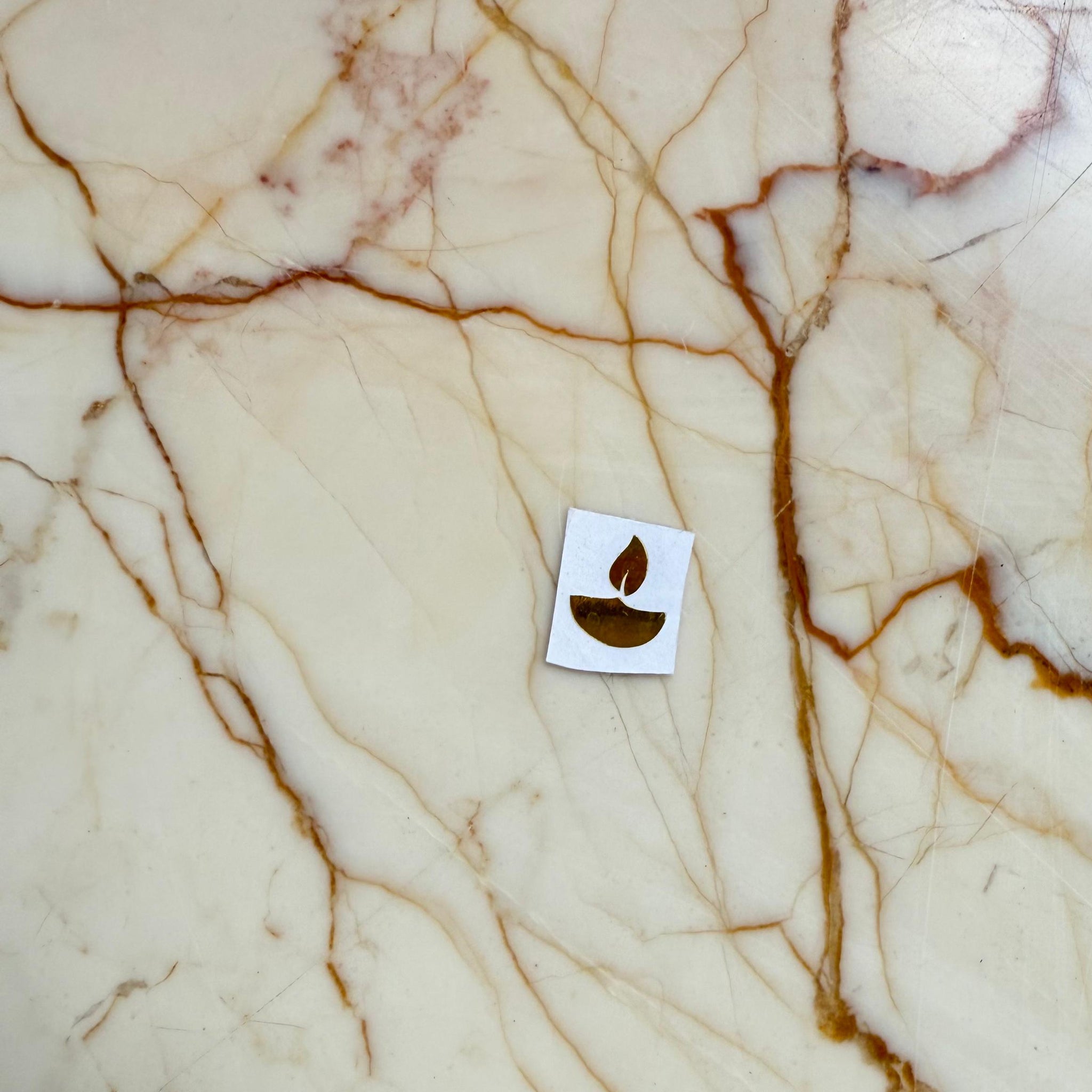 Marble surface with a small leaf icon in the center