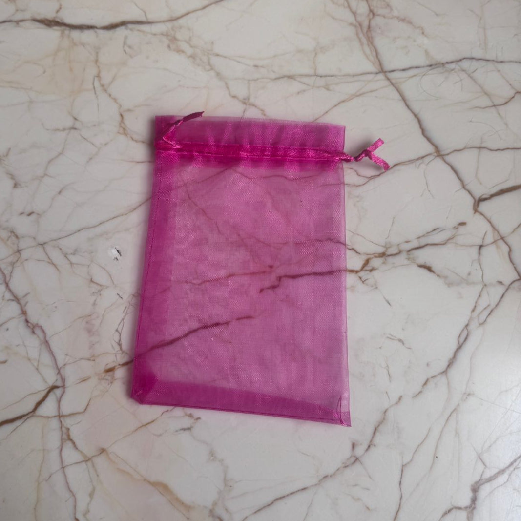Pink drawstring bag on a marble surface