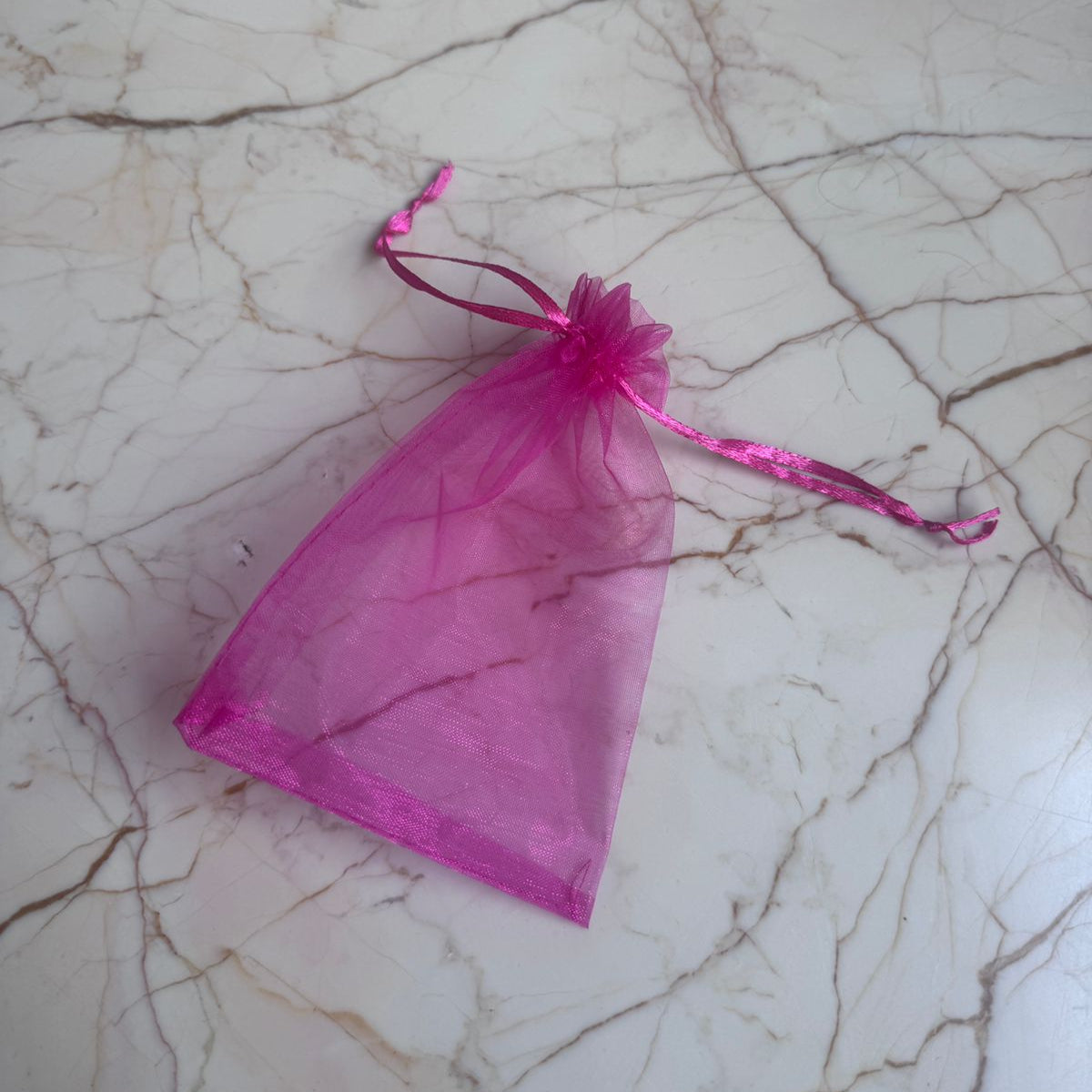Pink organza bag on a marble surface
