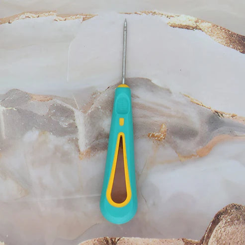 candle wick needle with a turquoise handle and yellow accent on a marble surface